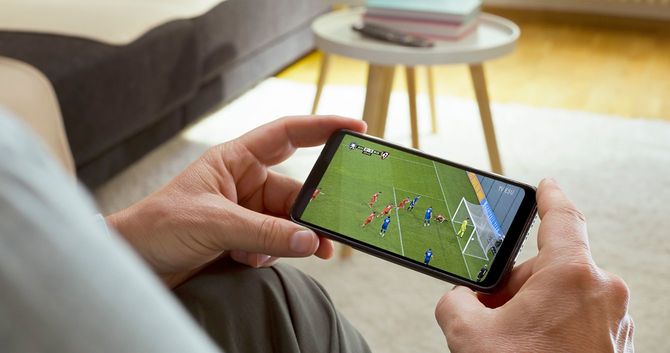スマホでサッカーの試合を見ている人