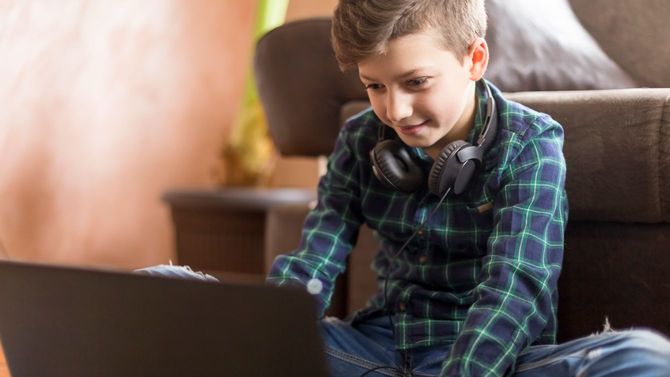 ノートパソコンでゲームをする少年