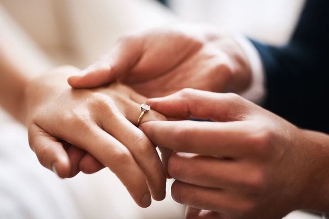 女性の薬指にダイヤの婚約指輪をはめている
