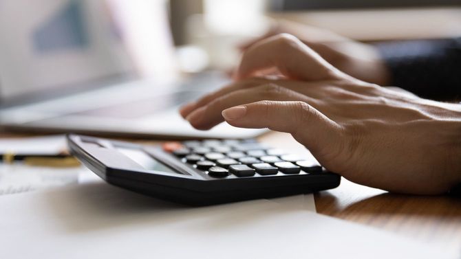 ノートパソコンを使いながら、左手で計算機で計算