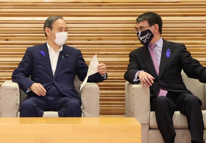 閣議前、河野太郎行政改革担当相（右）と話す菅義偉首相＝2021年7月9日、首相官邸