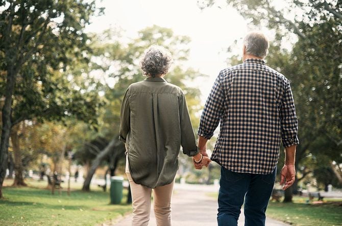 手をつないで歩く高齢の夫婦