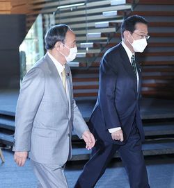 首相官邸を訪れた菅義偉前首相(左)を出迎える岸田文雄首相=2021年11月11日、首相官邸