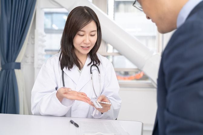 処方薬を説明する女性医師と男性患者