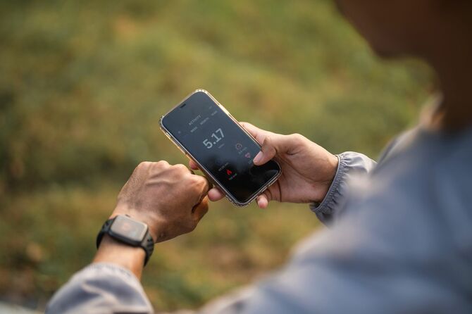 スマートフォンの健康アプリをチェックする男性