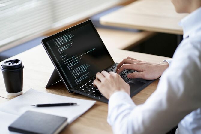 ラップトップでコードを書くアジアのプログラマー