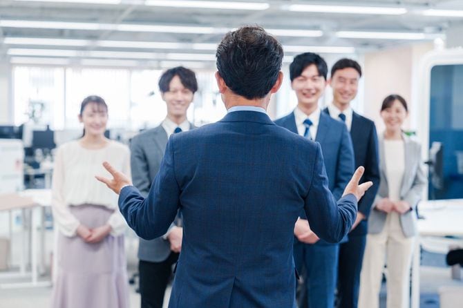オフィスで朝礼をするビジネスパーソン
