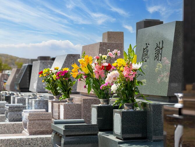 青空を背景に並ぶ墓石