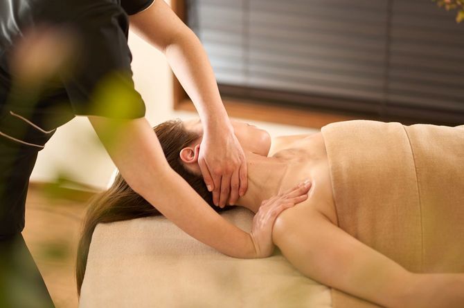 エステで首のマッサージの施術を受けている女性