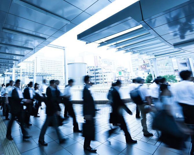 雨の朝に歩行者通路を歩く通勤者の群衆