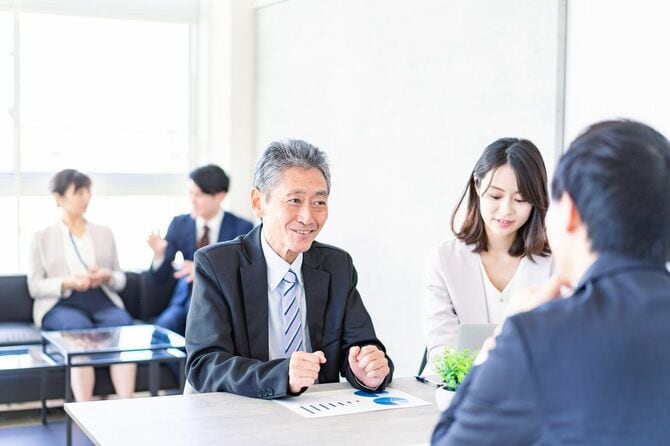 ミーティングをするシニアビジネスマンと若いビジネスパーソン