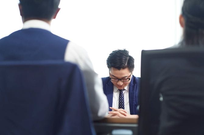 面接でうつむき、悲しそうにみえるビジネスマン