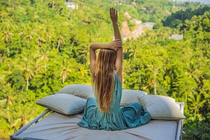 ジャングルの上のベッドで若い女性。自然との親密さ。