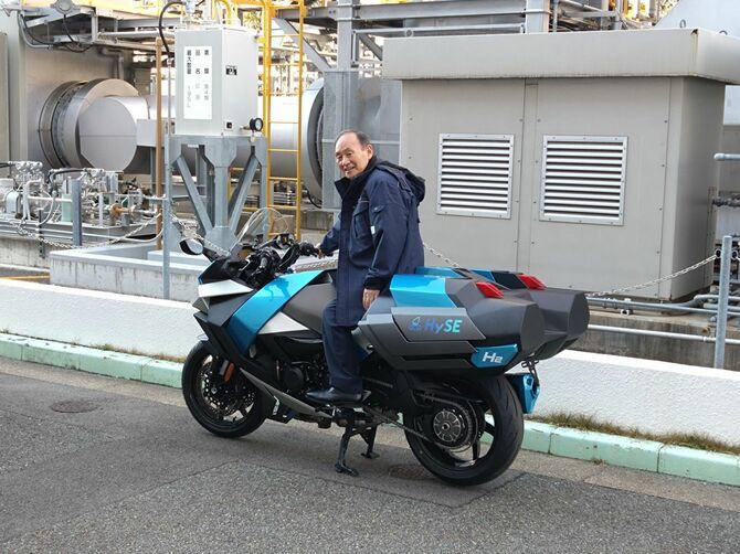 水素エンジンを搭載したバイクにまたがる自民党の菅義偉前首相