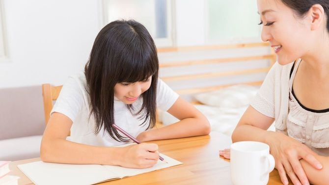 勉強する娘と付き添う母親