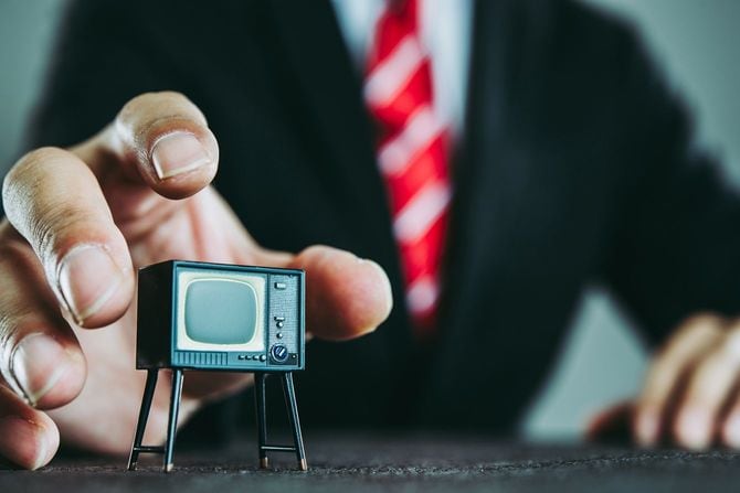 テレビを手中に収めんとする男性