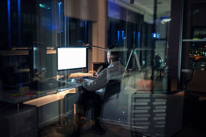 夜遅くまでオフィスで残業をする男性