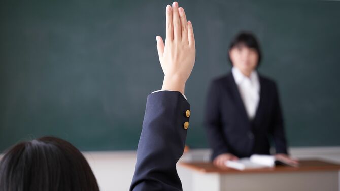 クラスで授業中に挙手する女子生徒