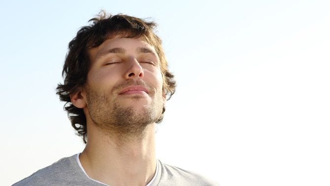 野外で深呼吸する男性