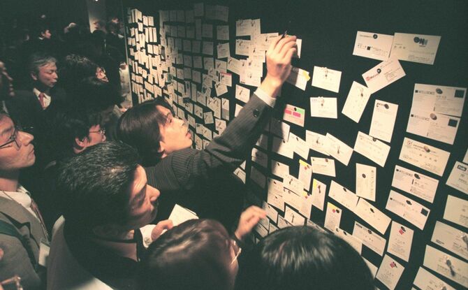 名刺ボードを見つめる若者