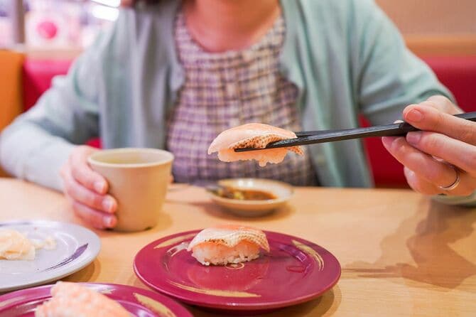 回転寿司のお店で寿司を食べる女性