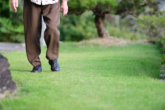 庭を歩く年配の女性
