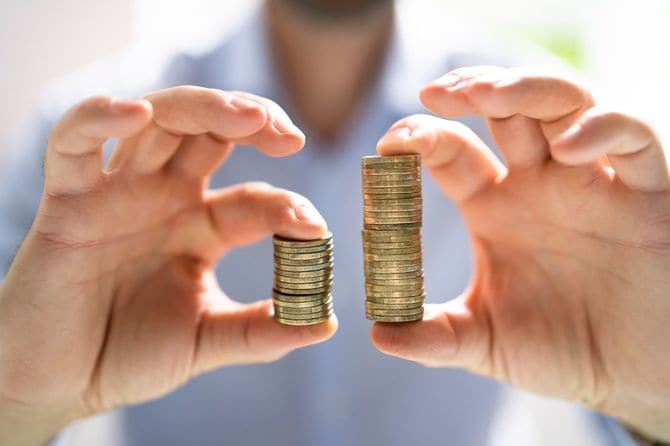 左右の手に持たれたコインの量の違い・賃金格差のイメージ