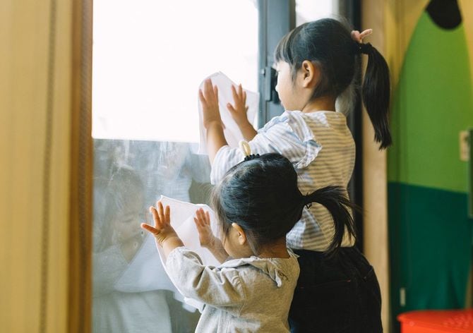 二人の小さな女の子が窓を掃除