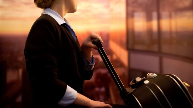 空港で荷物を待つキャビンアテンダント