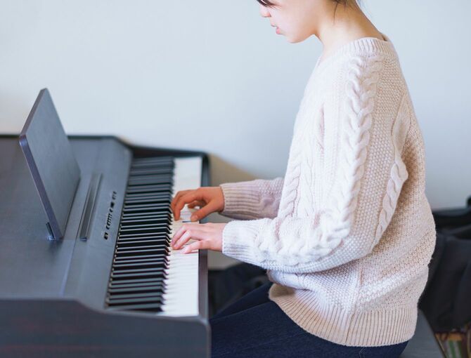 電子ピアノを弾いている少女