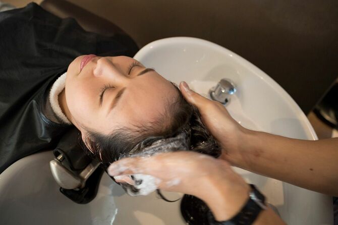 客の髪を洗う美容師