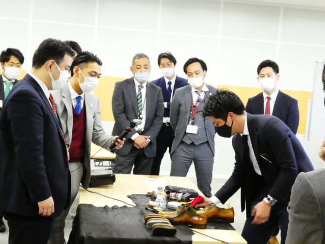 企業への出張靴磨き。参加者にアドバイスしながら靴を磨く濱岡さん