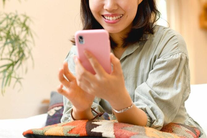 自宅でスマートフォンを操作する女性