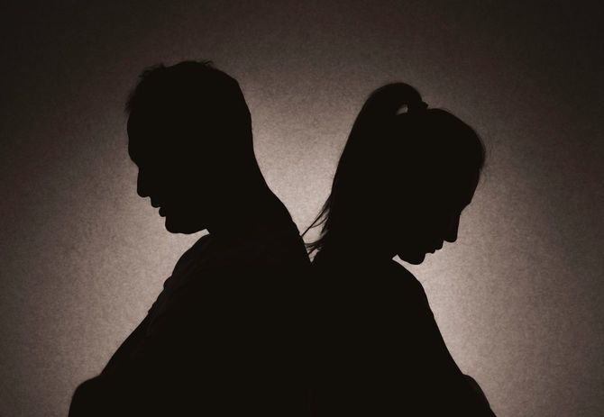 背中合わせでそれぞれ腕を組んだ、問題のあるカップル