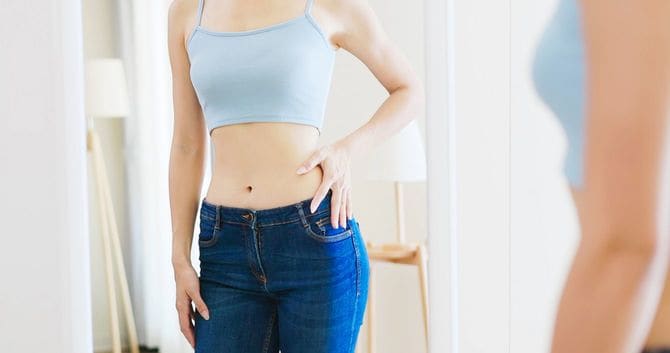 鏡で体型を確認する女性