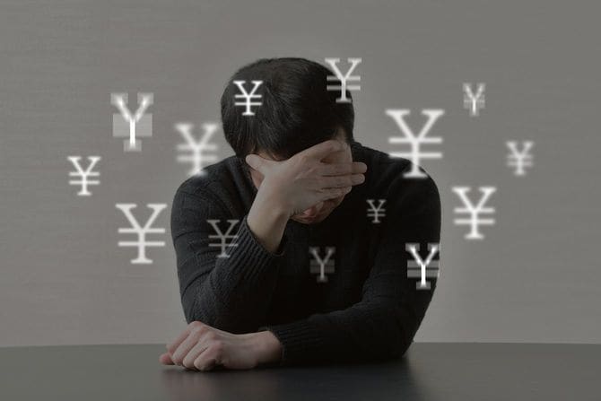 お金のことで不安に押しつぶされそうな男性