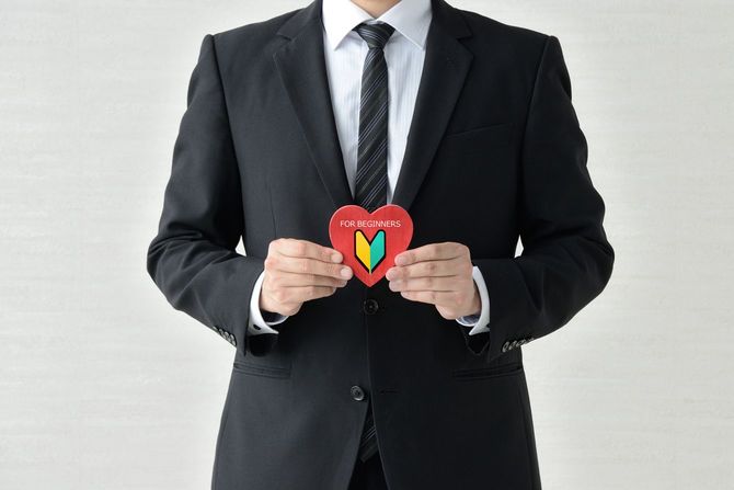 初心者マーク入りのハートを手に持つビジネスマン