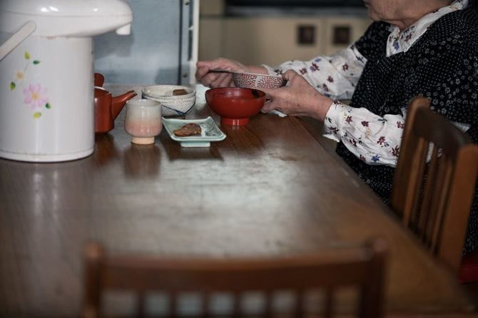 孤独に食べる年配の日本人女性