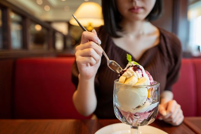 レストランでパフェを食べる女性