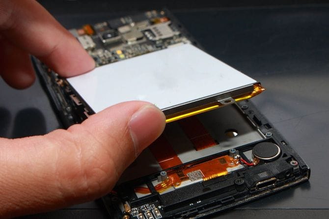 スマートフォン内部をいじっている手元