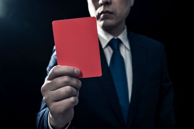 レッドカードを提示する男性