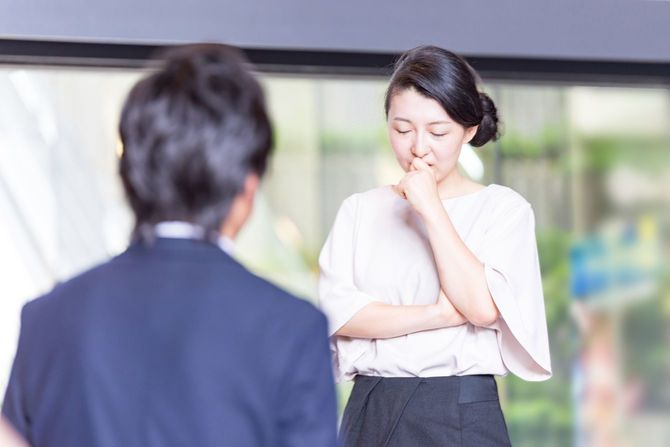 女性の話を聞いているビジネスマン
