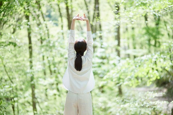 自然の中で森林浴を楽しむ女性