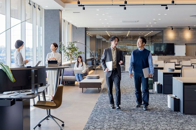 オフィスで歩きながら話をする社員たち