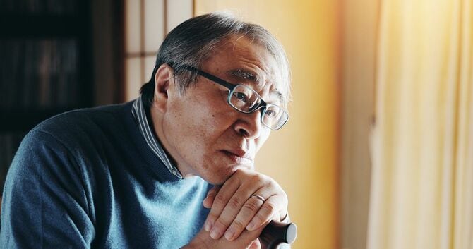 杖を持ってぼーっとする日本人男性