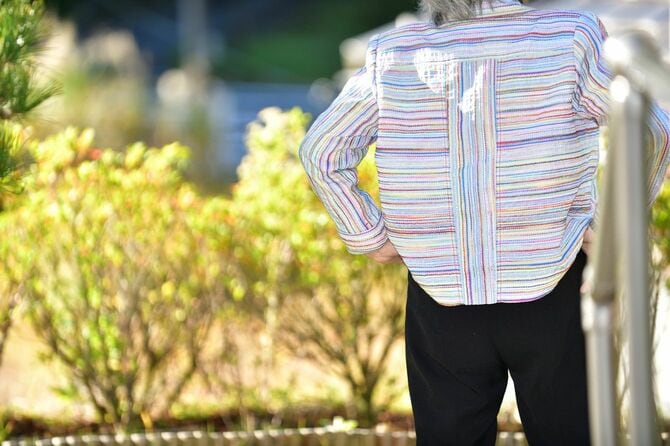 手すりを持つ年配の女性