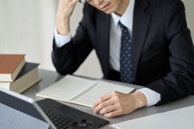 考え事をする会社員のイメージ
