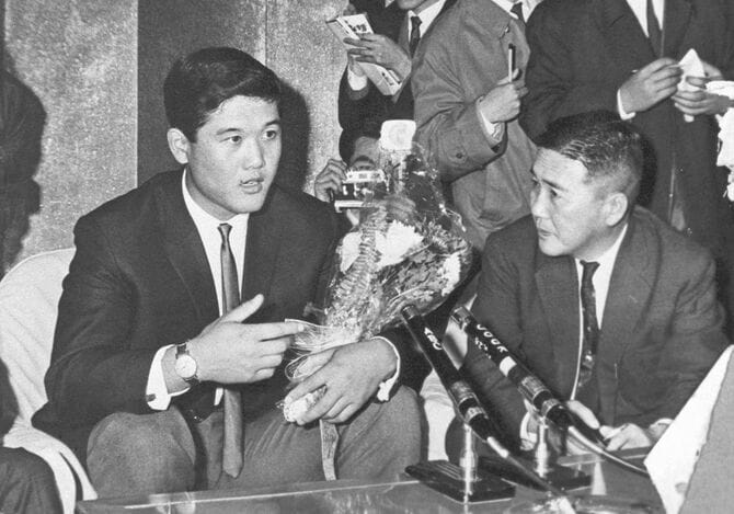 米大リーグのジャイアンツでメジャーデビューし、羽田空港で記者会見する村上雅則投手（左）＝1964年12月、共同通信