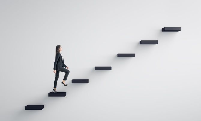 若いビジネスウーマンが階段を上がっていく