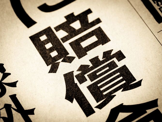 見出しに踊る「賠償金」の文字